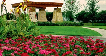 Red and pink flowers in front of woodcreek entry