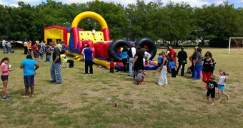 Woodcreek event lawn with a bounce house and obstacle course with kids