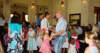 group of small children and parents dancing in clubhouse at Woodcreek