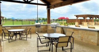 tables under pavilion with two summer kitchens that look out to the pool